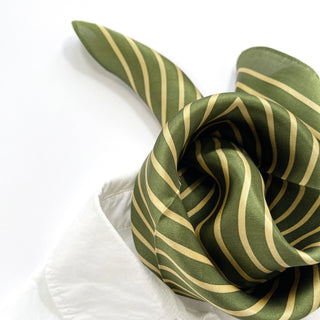 Moss green silk bandana with gold diagonal stripes displayed in elegant folds, showcasing the scarf's lustrous texture on white background