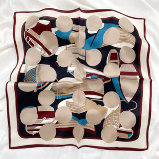 Burgundy Bauhaus Harbor silk scarf with geometric pattern featuring beige circles, blue shapes, and burgundy accents on navy background with white border