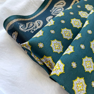 Pacific blue silk neckerchief with yellow octagonal star medallions and elegant paisley border pattern, displaying luxurious sheen on white background