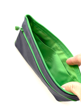 Recycled double zipper wallet in navy blue with bright green trim and interior, showing open compartment with piping detail