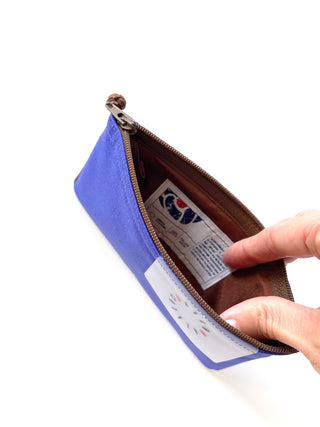 Bright blue recycled RPET zipper wallet open to show brown interior with product label and decorative traditional Chinese button closure