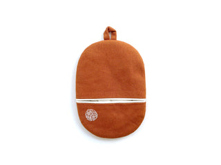 Terracotta orange linen oven mitt with white piping accent, circular embroidery detail, and hanging loop against white background.