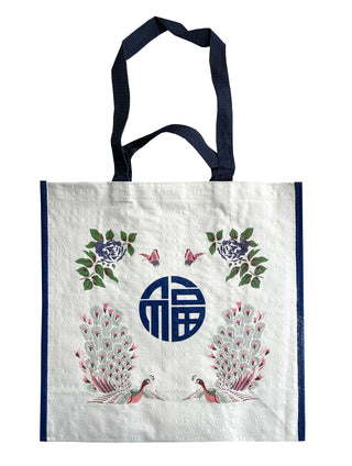 Vintage ethnic shopping tote with navy handles, featuring decorative peacocks, blue flowers, butterflies and a Chinese character in a circular design on white fabric.