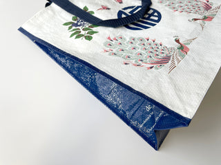 White recycled plastic tote bag with colorful peacock pattern, Chinese character design, blue trim and handles, eco-friendly shopping bag