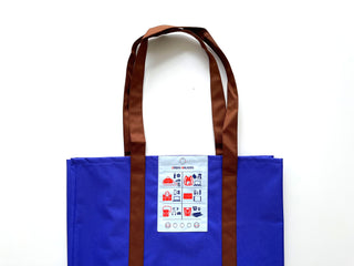 Recycled large tote bag in vibrant blue with brown straps, featuring Urban Walkers patch with travel icons. Spacious, eco-friendly shopping bag made from RPET material.