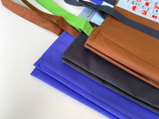 Recycled large tote bags displayed in multiple colors - blue, brown, gray, and green - showing the durable RPET fabric and neatly piped edges
