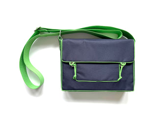 Navy blue preppy messenger bag with bright green trim and strap, featuring front pocket with green accents, made from eco-friendly RPET material