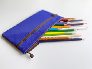 Bright blue recycled double zipper wallet/purse with brown zippers shown holding colorful pencils, displaying its multi-functional design and spacious compartments.
