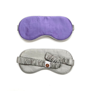 Luxury double-sided silk sleep mask shown in purple and silver colors with elastic band, featuring smooth fabric and contoured design for comfort